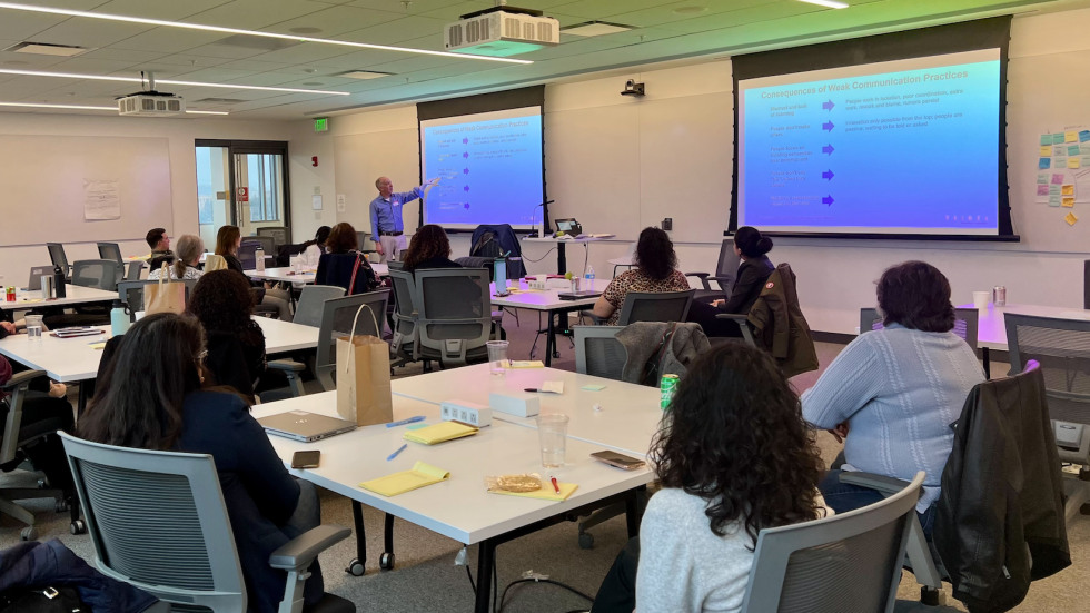two groups of employees gathered at tables in conference room 